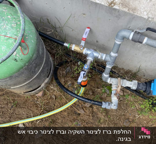 צנרת מים עם ברזים ומחברים על הקרקע